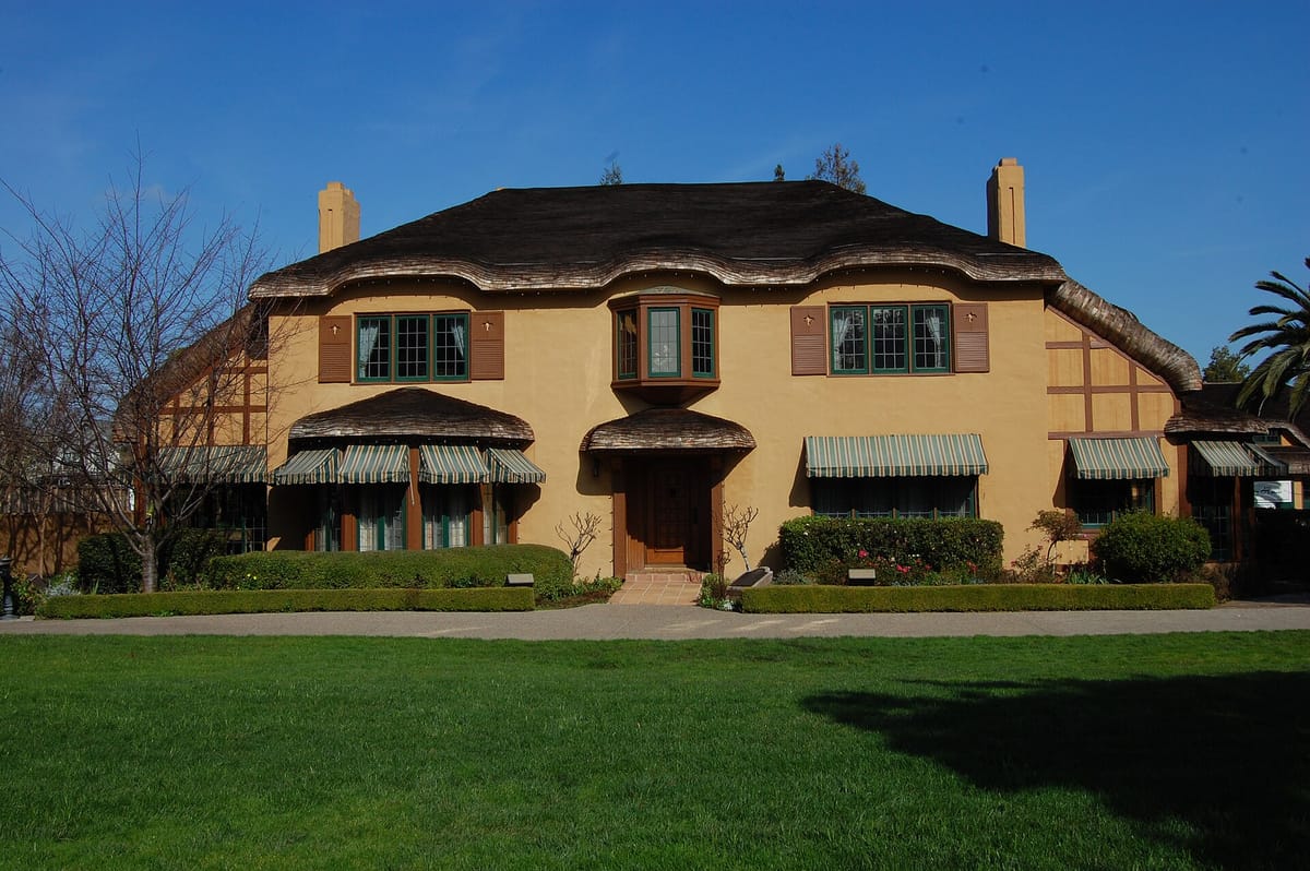 The Ainsley House and its gardens under a blue sky