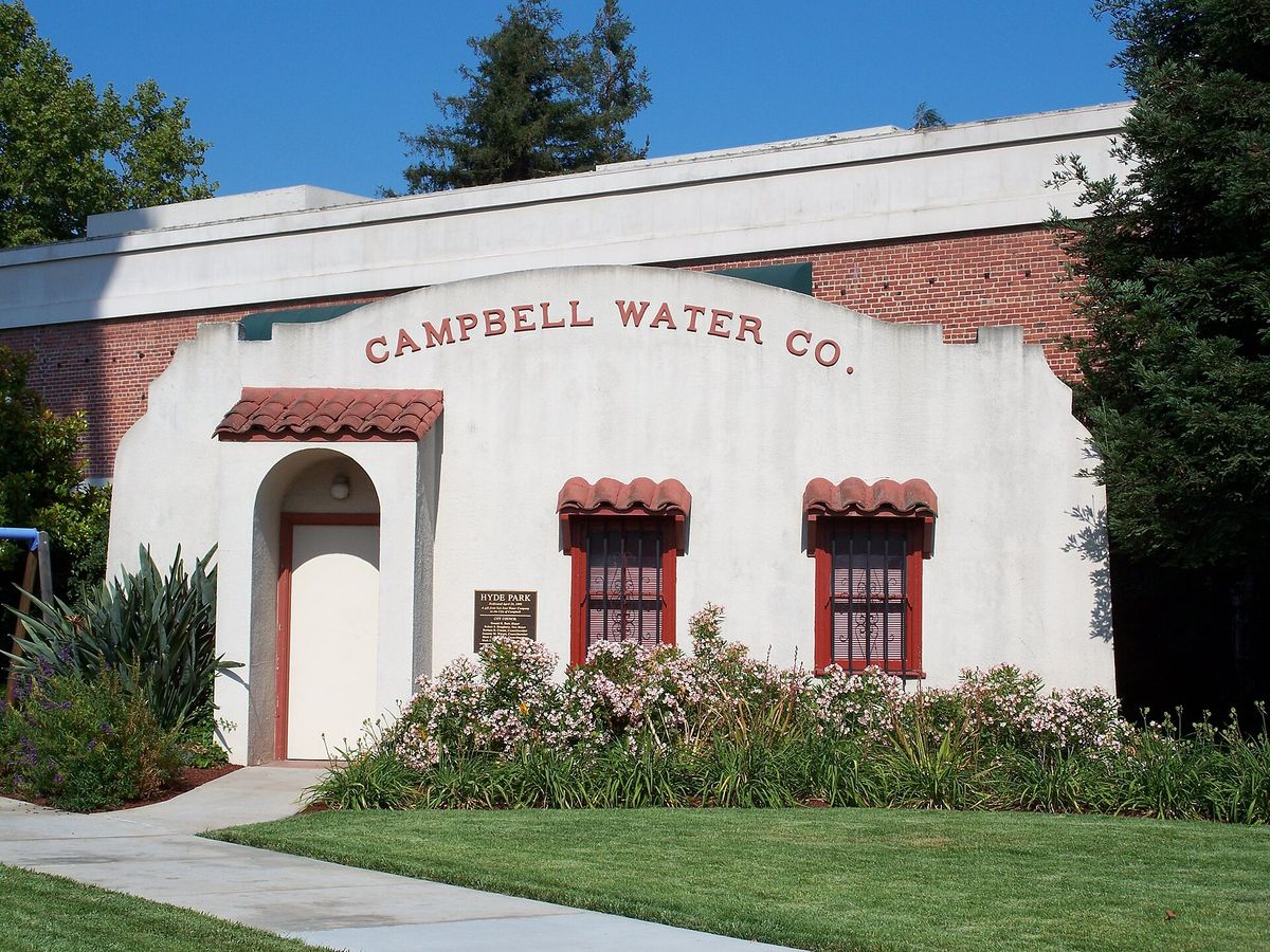 The white stucco Campbell Water Company pump house beside the tower