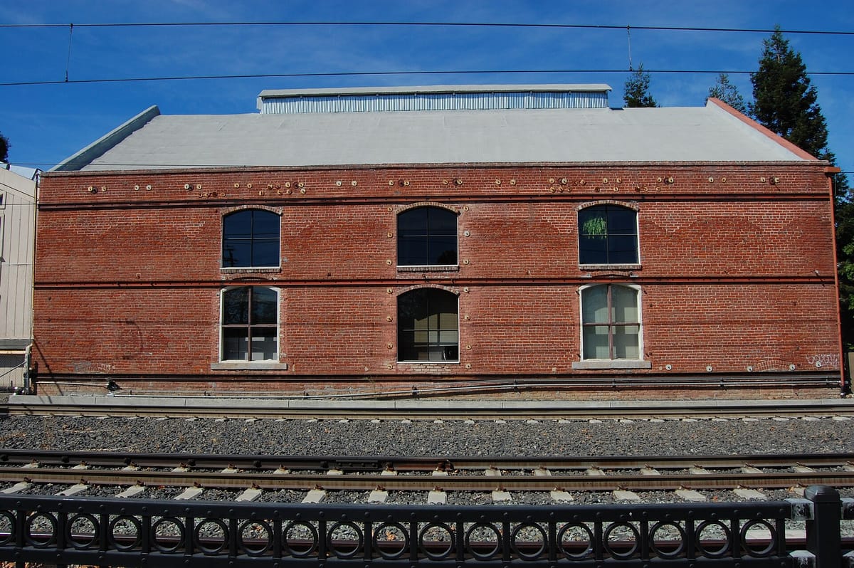 The brick George E. Hyde and Company building beside the railroad tracks