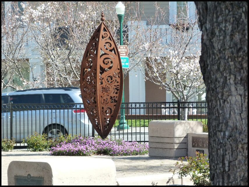A tall bronze seed-pod sculpture in downtown Campbell